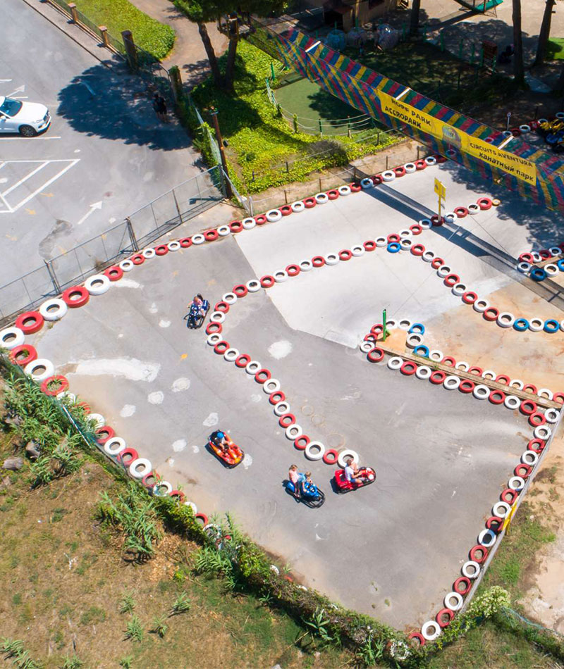 Vista aérea de una pista de karting al aire libre rodeada de neumáticos y vegetación en un día soleado